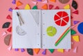 Geometry Set on open notebook. Compass Drawing Tool, ruler, pencils, multicolored fractions for mathematical education.