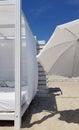 Geometry of white sunshade and beach umbrella shade on clear beach sand