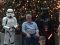 George Lucas director of starwars next to people dressed up as storm troopers and earth Vader for charity