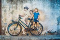 Georgetown, Penang, Malaysia - April 20, 2018: Boy on a bicycle. Public street art Name Children on a bicycle painted 3D on the wa