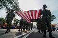 Low angle soldiers carry large Malaysia flag together.