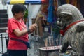 A woman worship in front of stone statue lion at Goddess of Mercy temple.