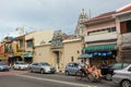 A street scene with an old Hindu temple, vintage shop houses and a man in a cycle