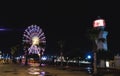 Georgia, Batumi. A white lighthouse with a red light at night. Night city. Illuminated Ferris wheel Royalty Free Stock Photo