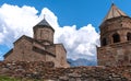 Georgia.Gergeti church near against a background of blue sky with white clouds.