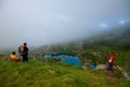 Georgia, Khevsureti - July 9, 2017: Three friends enjoy the beauty of a misty mountain lake