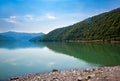 Georgia.Turquoise water of the Zhinvali reservoir.Reflection of mountains and clouds in the water of the lake.