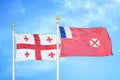 Georgia and Wallis and Futuna two flags on flagpoles and blue sky