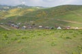 Georgia wooden houses, green fields and famous touristic Gomi mountain. Traditional Georgian Caucasus old cabins