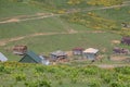 Georgia wooden houses, green fields and famous touristic Gomi mountain. Traditional Georgian Caucasus old cabins