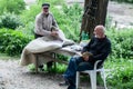 georgian man repairing clothes lying on the table, outdoors