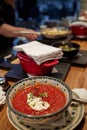 Georgian rich soup kharcho with meat in a deep orange plate on a wooden Board with herbs and cherry, onion and garlic on Royalty Free Stock Photo