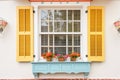 georgian style window with shutters and dentil trim above Royalty Free Stock Photo