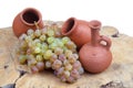 Georgian traditional decorative jugs for wine qvevri or kvevri and set of clay cups with grape on the wooden log slice Royalty Free Stock Photo