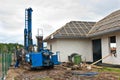 Geothermal drilling for house Heavy machine with drills next to newly constructed private house