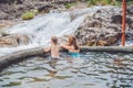 Geothermal spa. Mother and son relaxing in hot spring pool against the background of a waterfall Royalty Free Stock Photo