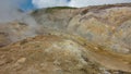 Geothermal zone on a mountain slope. The soil is covered with yellow-orange sulfur deposits. Royalty Free Stock Photo