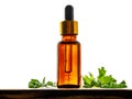 Geranium essential oil in dark glass bottle with fresh scented geranium leaves on old wooden board on white background Royalty Free Stock Photo