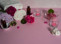 Geranium essential oil, geranium flowers and leaves, pink sea salt, candles and towels on pink background. Royalty Free Stock Photo