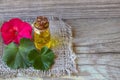 Geranium essential oil in a glass bottle with flowers and leaves of the geraniums plant on wooden table. Royalty Free Stock Photo