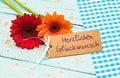 Gerbera daisy flowers with greeting card and german text, Herzlichen Glueckwunsch, means congratulation