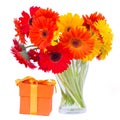 Gerbera flowers in glass vase with gift Royalty Free Stock Photo