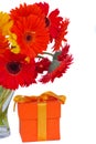 Gerbera fresh flowers in glass vase with gift Royalty Free Stock Photo