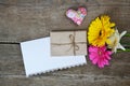 Gerberas flowers with two hearts, envelope and white paper on wood Royalty Free Stock Photo