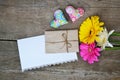 Gerberas flowers with two hearts, envelope and white paper on wood Royalty Free Stock Photo