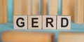 GERD word written on wooden blocks on light blue background