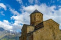 Gergeti Trinity Church, Georgia. Sunrise at the Gergeti Trinity Church with sunrays at chapel at the foot of Kazbegi mountain near Royalty Free Stock Photo