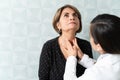 Geriatrician Examining Senior Patient In Clinic