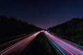 A german Autobahn at night with lighttrails of the fast driving cars in red, wallpaper photo for a high speed concept. Royalty Free Stock Photo