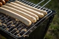 German Bratwurst sausages of pork meat roasting on foldable charcoal BBQ barbecue grill in garden on summer evening Royalty Free Stock Photo