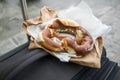 German Brezel pretzel with chives, butter and cream cheese on bakery bag and suitcase as snack on the go during travelling