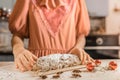 German culinary tradition on Christmas Eve. Caucasian girl in festive dress prepared traditional German holiday Stollen cupcake.