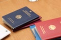 German diplomatic passport and others on a wooden table, close-up. Border crossing, travel, immigration concept