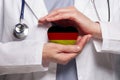 German doctor holding heart with flag of Germany background. Healthcare, charity, insurance and medicine concept Royalty Free Stock Photo
