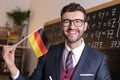 German educator holding national flag in classroom