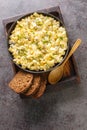 German egg salad with apples and pickles dressed with mayonnaise close-up in a bowl. Vertical top view