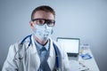 German European young doctor looking at camera wearing glasses and mask in clinic office at workplace with tired look Royalty Free Stock Photo