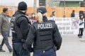 A German female police officer standing in front of a group of protestors