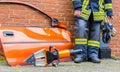 German firefighter stands near a car door with an emergency tool