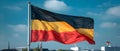 German Flag Billows Against Blue Sky - Symbol of National Pride. Concept German Flag, Blue Sky,