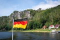 German flag in front of Elbe sandstone mountains at Rathen near Bastei Bridge (Basteibrucke) - Saxony, Germany