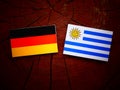 German flag with Uruguaian flag on a tree stump Royalty Free Stock Photo