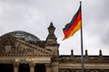 The German flag waves at the Bundestag, the building of the German parliament. Cloudy sky Royalty Free Stock Photo