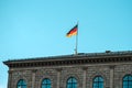 German flag waving on silver flagpole,  building in Munich Royalty Free Stock Photo