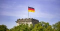 German flag waving on silver flagpole, Reichstag building in Berlin. Blue sky with clouds background Royalty Free Stock Photo