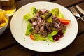 Salad from boiled veal, vegetables and onion at white plate